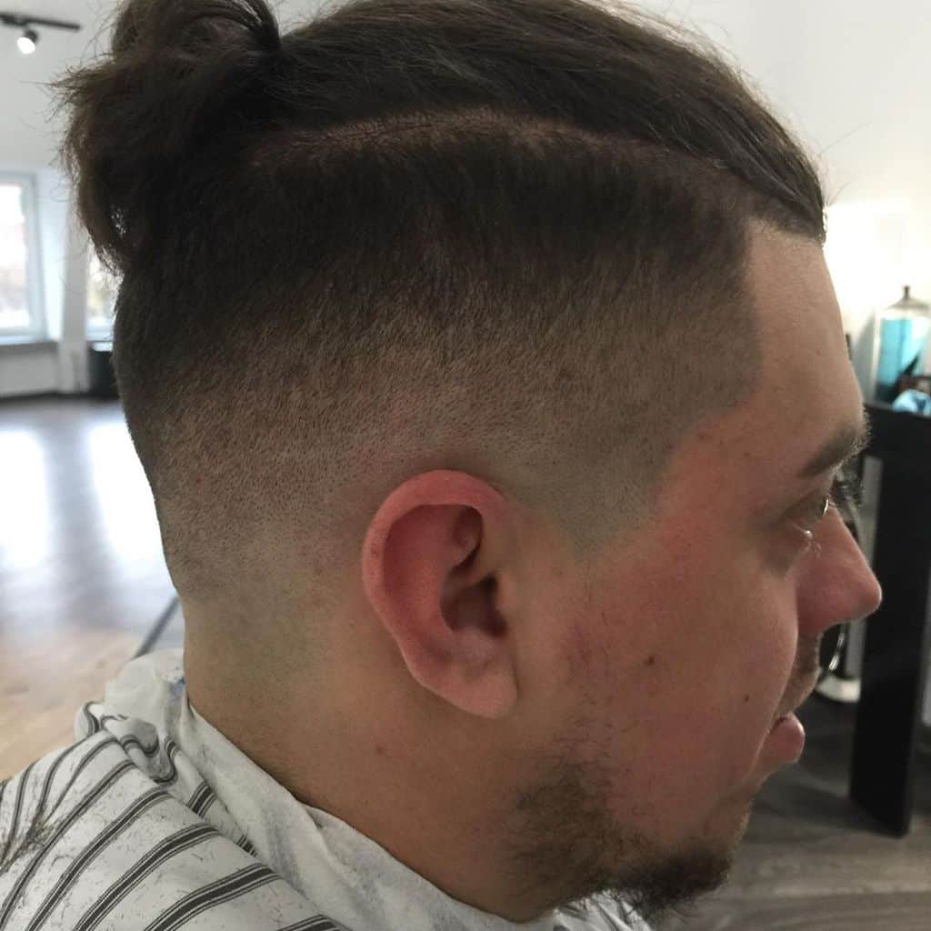A Man Bun Hairstyle Paired With Undercut And Taper Fade. A Standout Look For Stylish Men