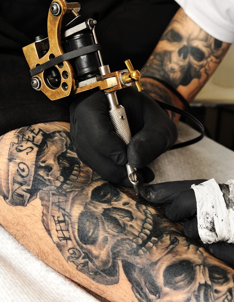 Man Being Tattooed with Skulls