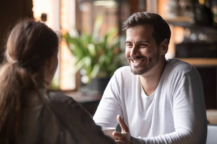 Man smiling while talking with a woman