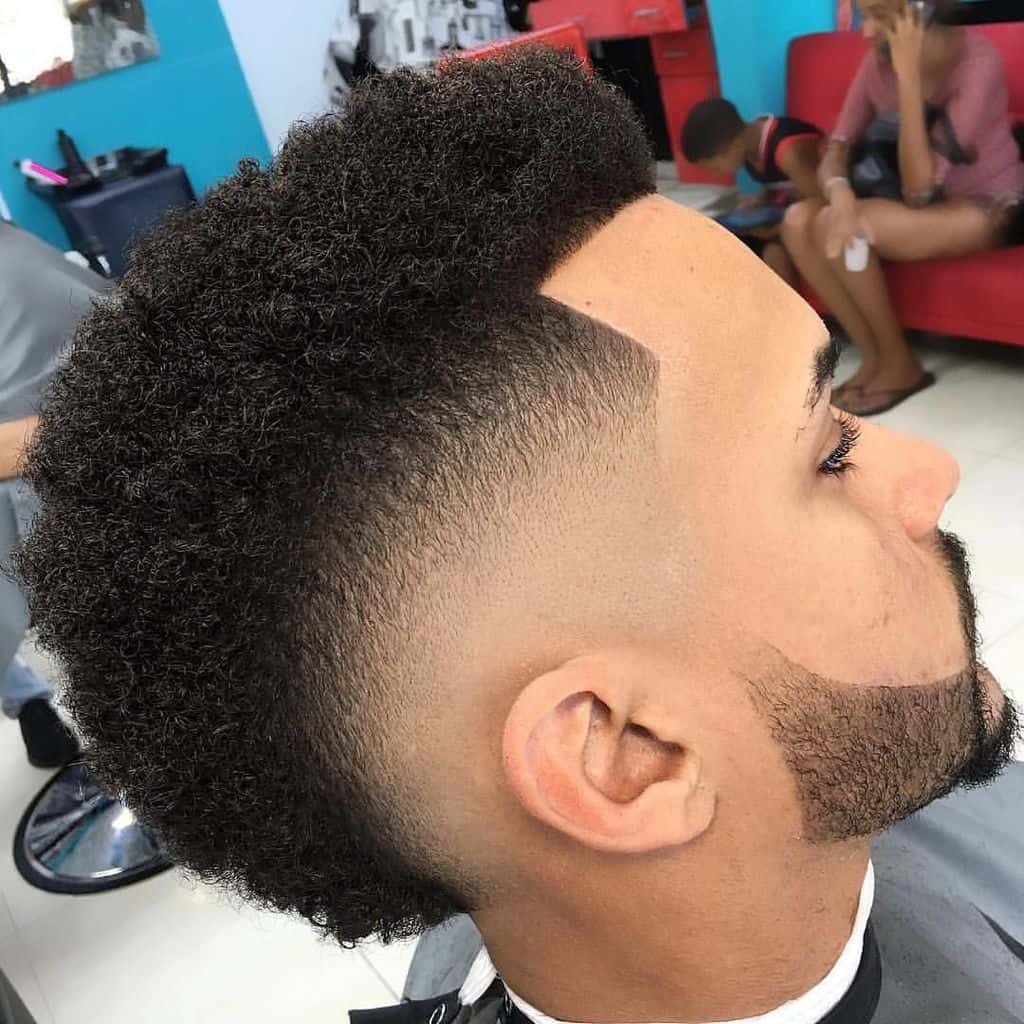 A fohawk haircut combined with a mid-fade cut and beard