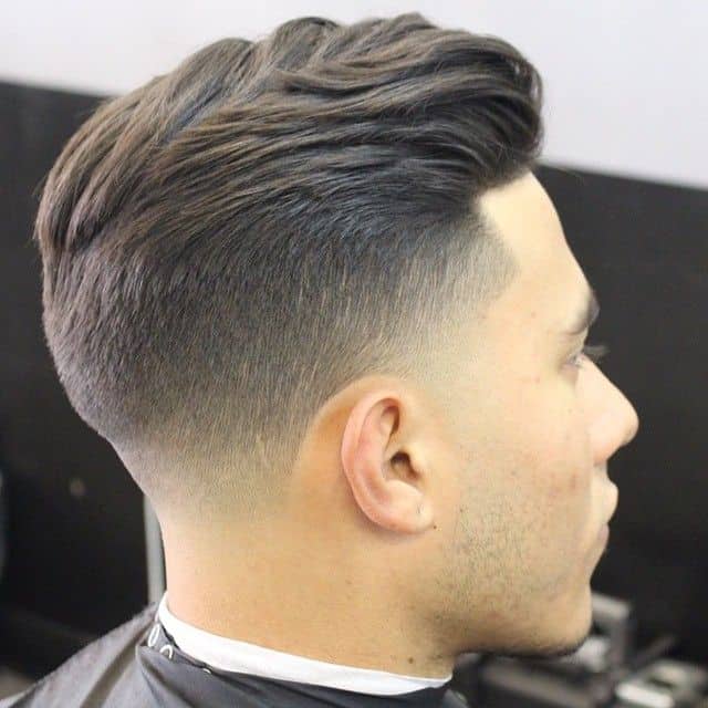 A hairstyle featuring a high fade and tapered sides to reveal the scalp