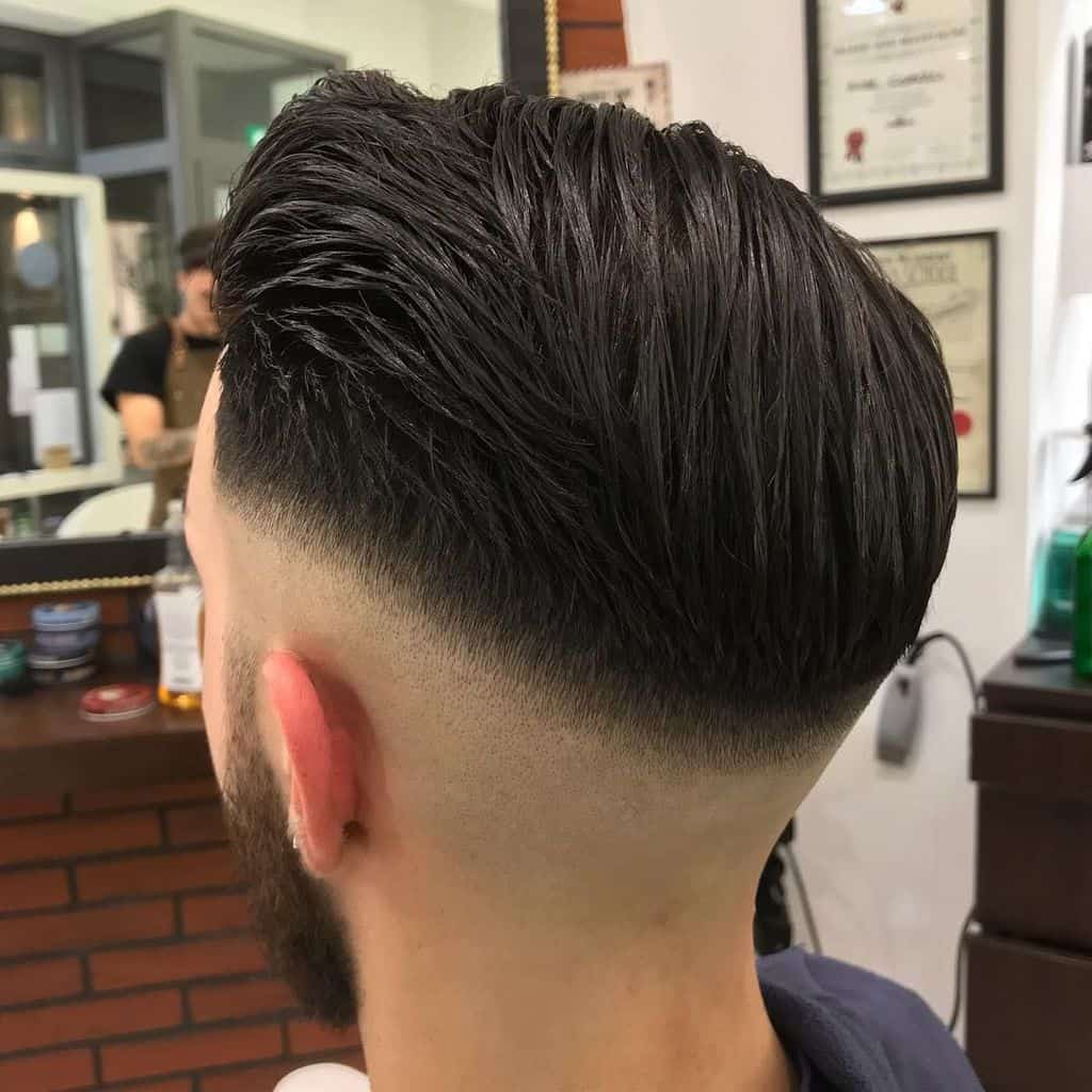A haircut with long tresses on top matched with a mid-fade cut and beard