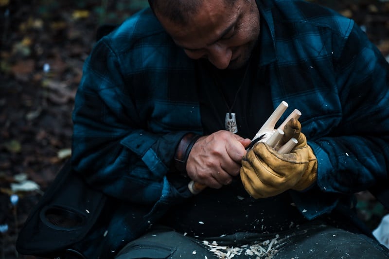 Close,Up,Of,Man,Carving,Branch,With,Knife,In,Nature